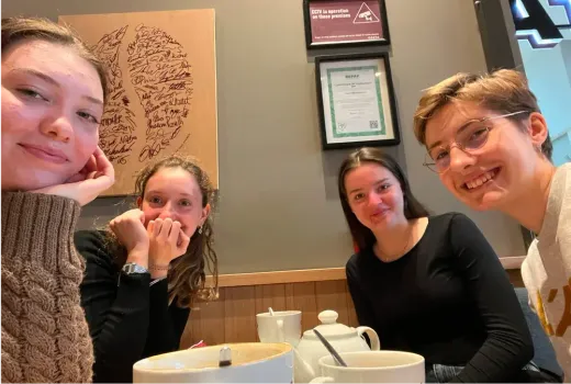 Vier Mädchen lächeln an einem Cafétisch in Irland