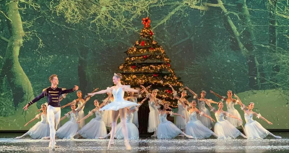 Studenti della Calabasas High School ballano sul palco davanti a un grande albero di Natale.