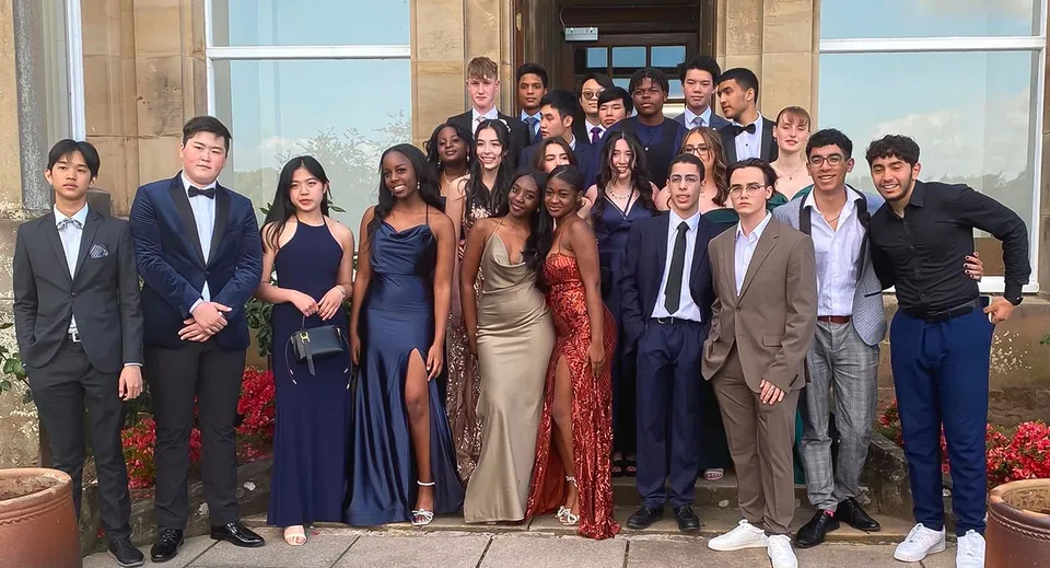 Un gruppo di persone posa davanti al grande edificio della Lime House School.