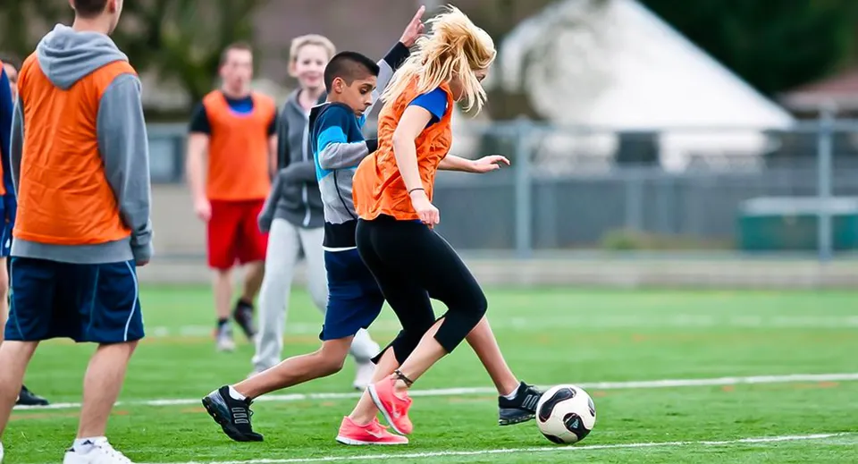 Studenti della Westview Secondary School giocano a calcio su un campo d'erba.
