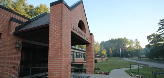L'ingresso in mattoni della Houghton Academy con il nome della scuola sopra l'arco e alberi sullo sfondo.