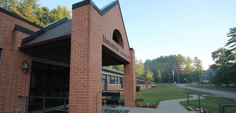 L'ingresso in mattoni della Houghton Academy con il nome della scuola sopra l'arco e alberi sullo sfondo.