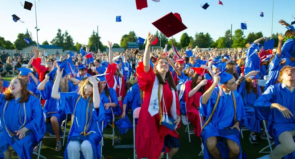 Gli studenti della Collège Churchill High School festeggiano la loro cerimonia di diploma all'aperto e lanciano i loro tocchi in aria.