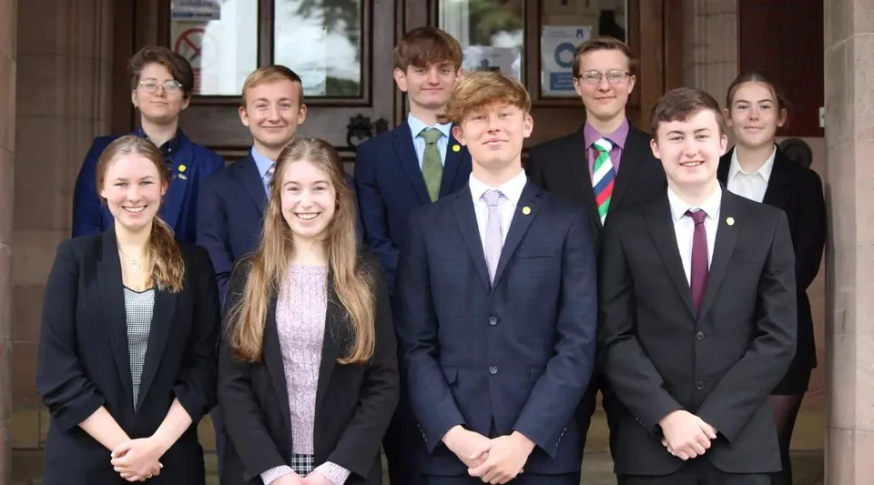 Un gruppo di studenti in abiti formali è davanti all'edificio della Longridge Towers School.