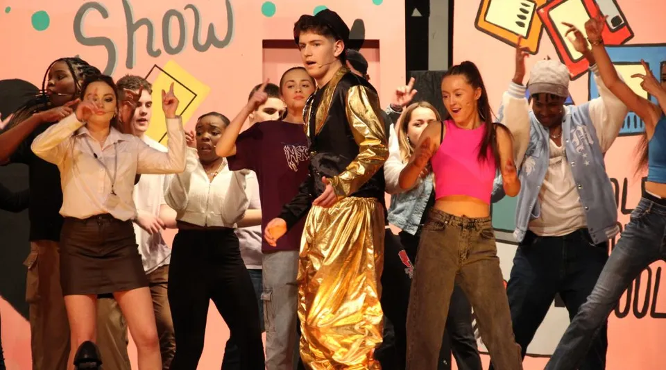 Un gruppo di studentesse e studenti si trova davanti a uno sfondo con la scritta Show nel campus della Colaiste Muire Mathair.
