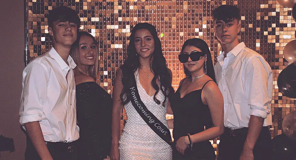 Un gruppo di studentesse e studenti della Life Prep Academy sta davanti a uno sfondo metallico in abito formale e casual.