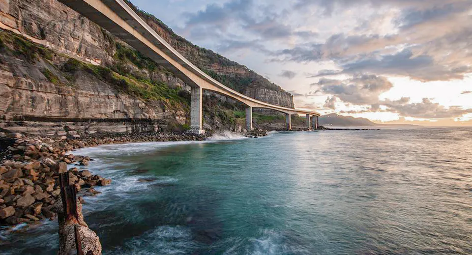 Strada costiera con ponte e rocce sulla costa marina vicino alla Craigslea State High School.