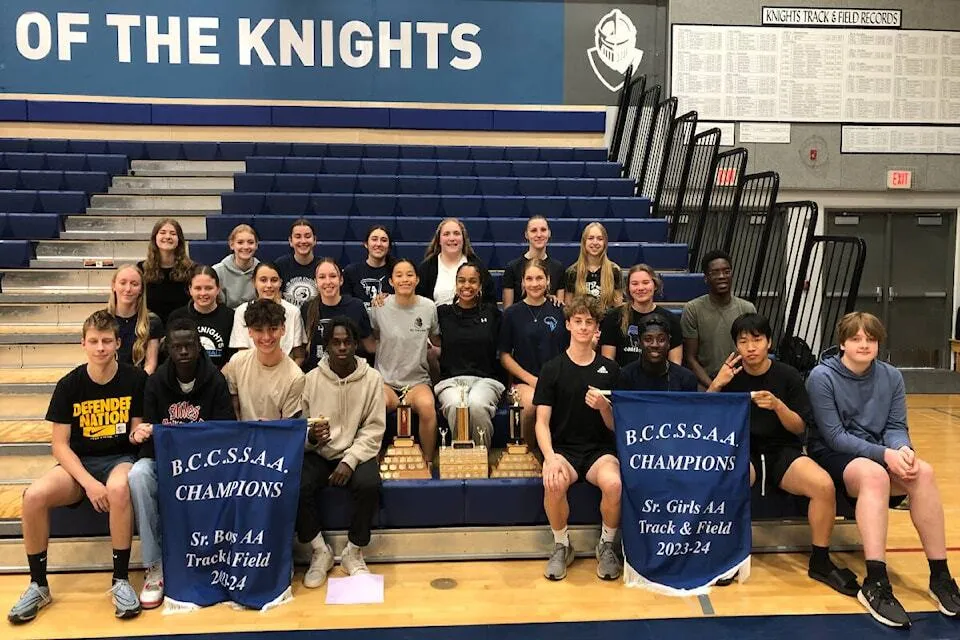 Un gruppo di studenti della Abbotsford Christian School posa in palestra davanti ai banner della società sportiva.