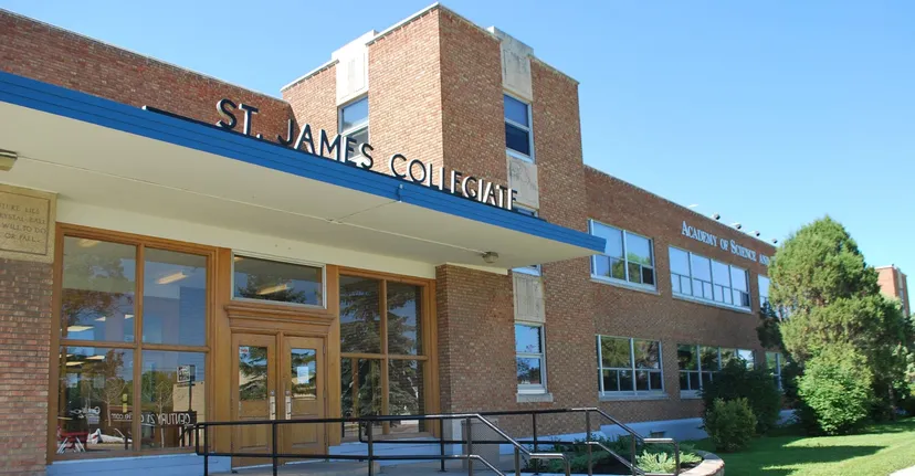 L'edificio in mattoni del St. James Collegiate è circondato da alberi e da un prato.