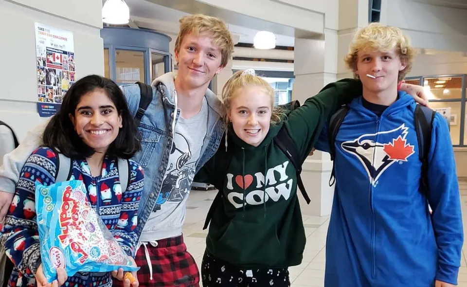 Un gruppo di quattro studenti sta insieme all'interno della H.J. Cambie Secondary School.