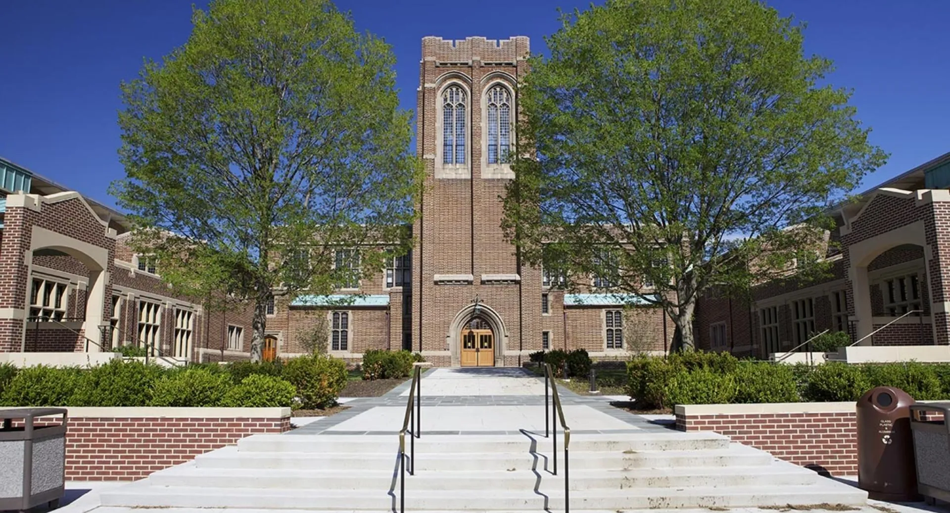 La torre gotica in mattoni della Mercersburg Academy è circondata da una verde vegetazione e da un sentiero pavimentato.