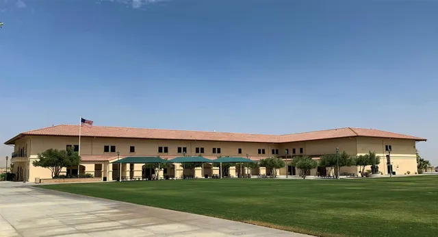 L'edificio principale a due piani della Xavier College Preparatory High School si trova davanti a un cielo azzurro e limpido, circondato da un prato ben curato e da palme.