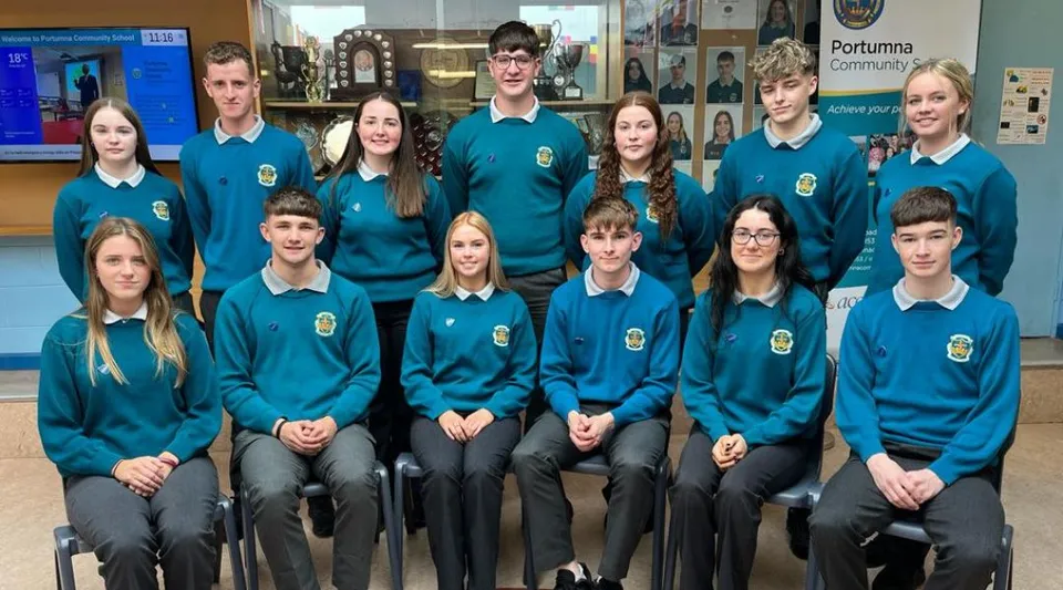 Un gruppo di studenti e studentesse in uniforme nell'edificio scolastico del Portumna Community College.