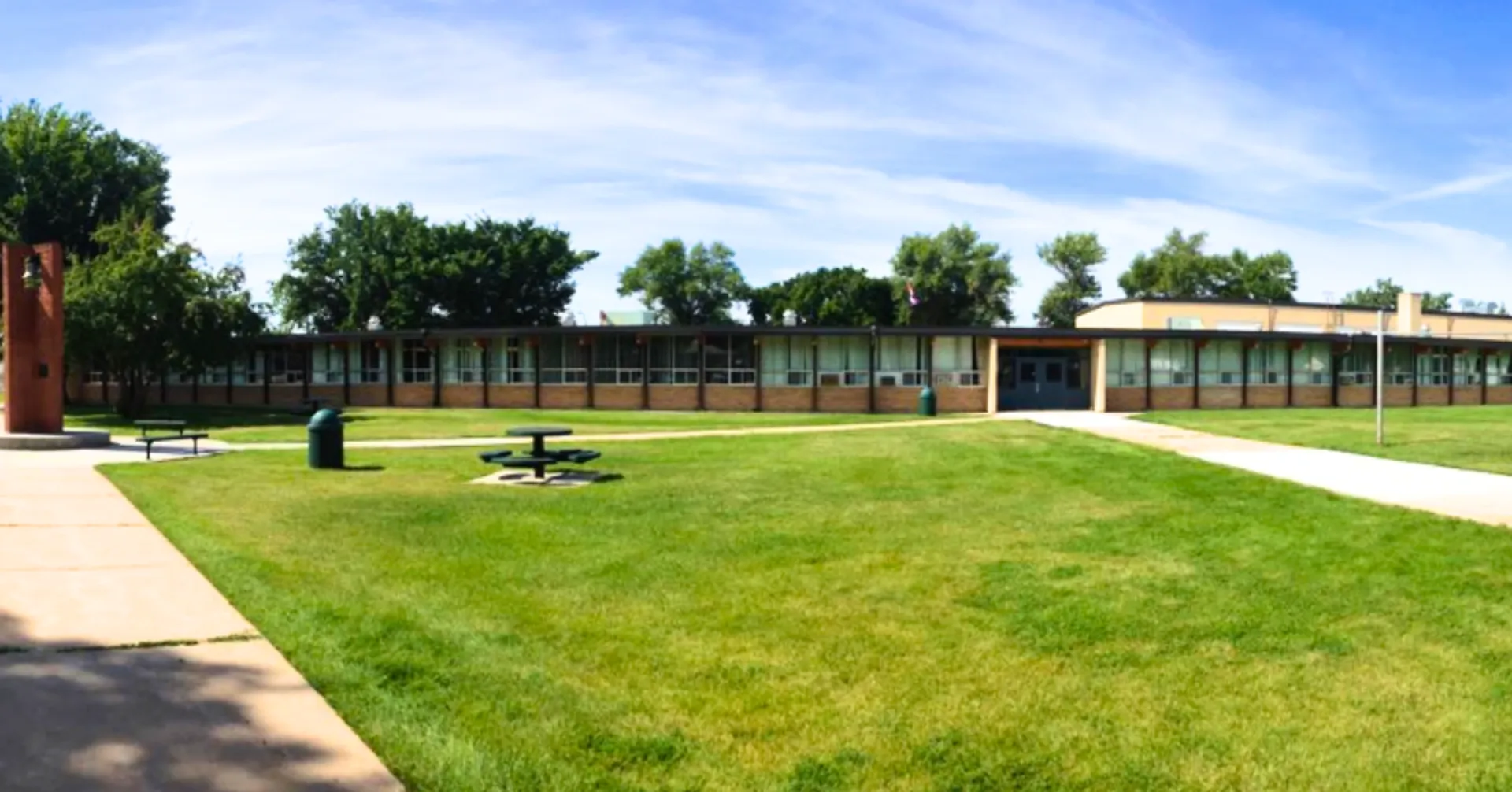 L'edificio a un piano della Senator Gershaw School con un ampio prato e un viale pedonale in primo piano.
