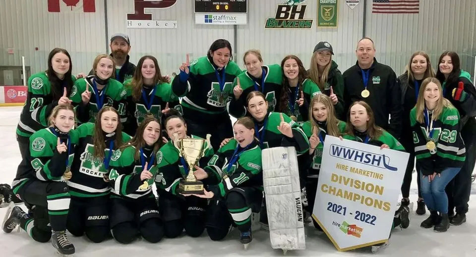 Le studentesse del Murdoch Mackay Collegiate festeggiano insieme a un trofeo la loro vittoria al campionato di hockey.