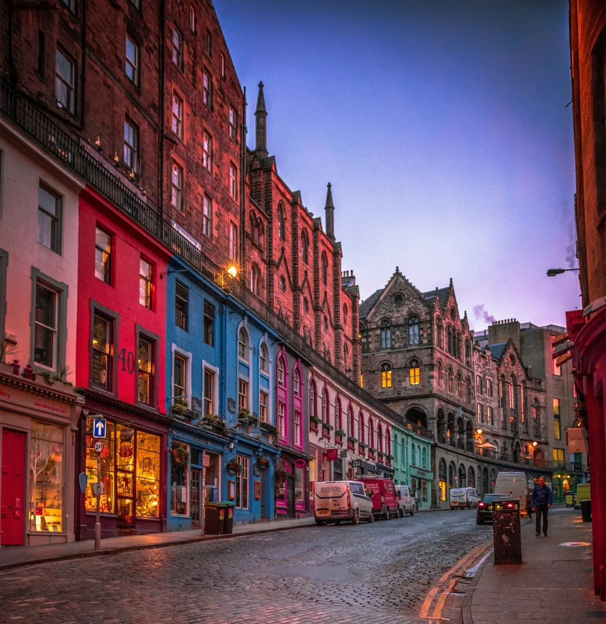 Victoria Street a Edimburgo con le facciate colorate dei negozi e la strada acciottolata bagnata