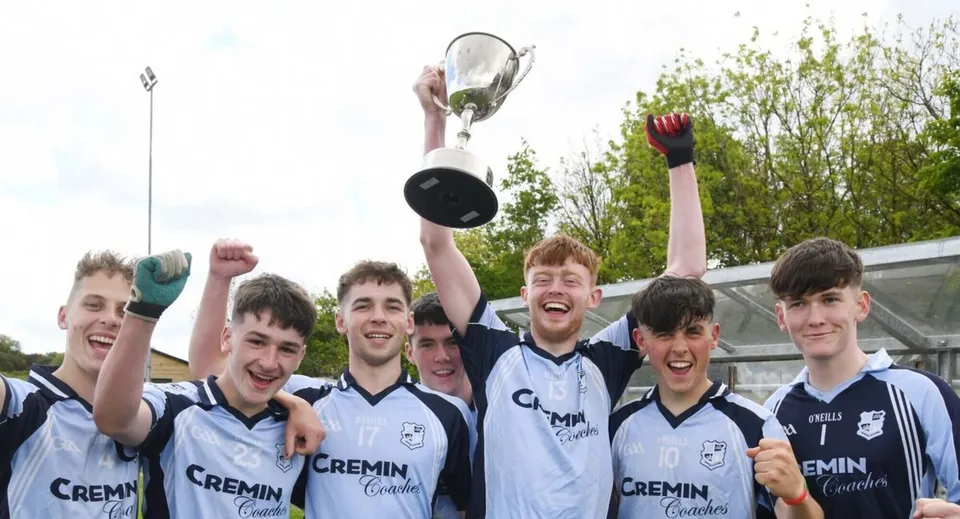 Gli studenti del Bantry Community College festeggiano sul campo sportivo con una coppa in mano.