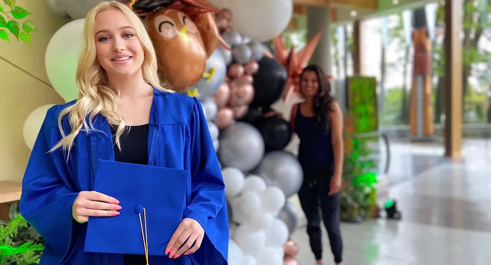 Una studentessa si trova nel corridoio con palloncini colorati sullo sfondo nel campus della Argyle Secondary School.