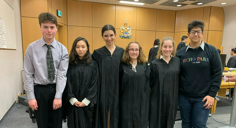 Studenti della Thornhill Secondary School in abito formale davanti a uno stemma.