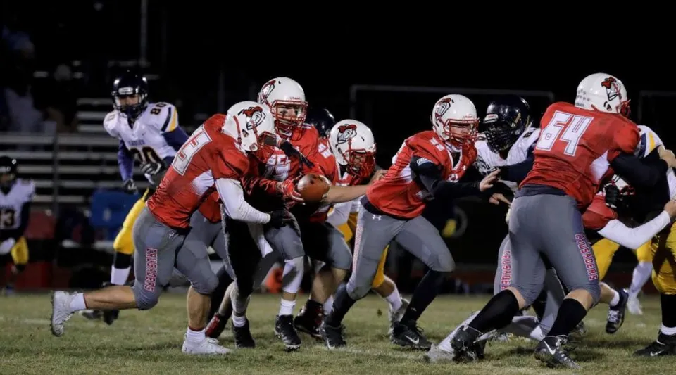 Un gruppo di giocatori di football americano gioca sul campo della St. Croix Lutheran Academy.