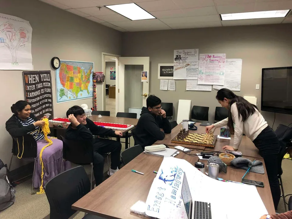 Un gruppo di studenti lavora insieme a un tavolo nella sala studio della Washington Preparatory School.