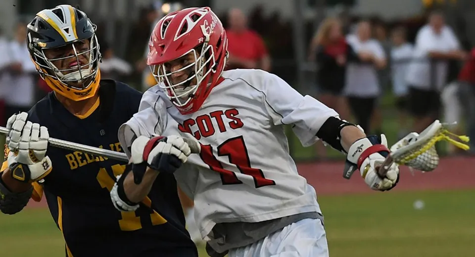 Due giocatori di lacrosse della Saint Andrews School si affrontano sul campo sportivo durante una partita.