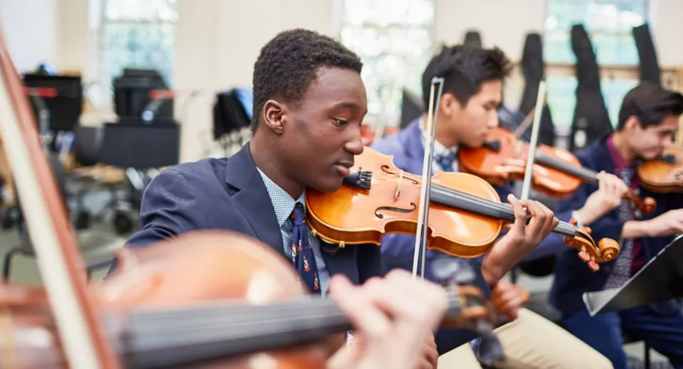 Uno studente del De la Salle College a Macroom suona il violino durante un'esibizione musicale con altri musicisti.