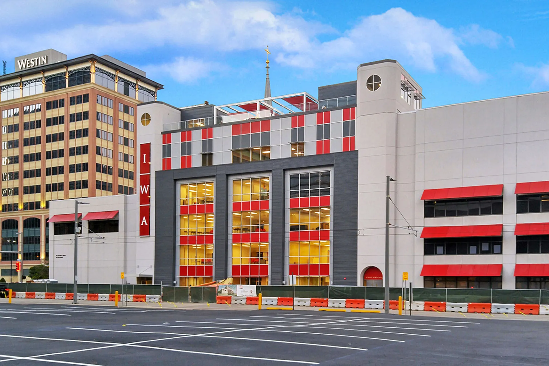 L'edificio moderno a più piani con facciata rossa e gialla nel campus della Incarnate Word Academy è circondato da grattacieli.
