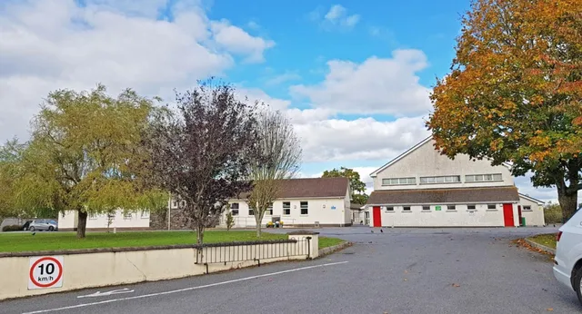 Vista su una zona residenziale con edifici antichi e moderni e alberi autunnali vicino alla Scoil Aireagail.
