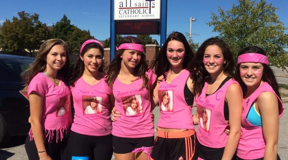 Un gruppo di studentesse si trova davanti all'edificio della chiesa della All Saints Catholic Secondary School.
