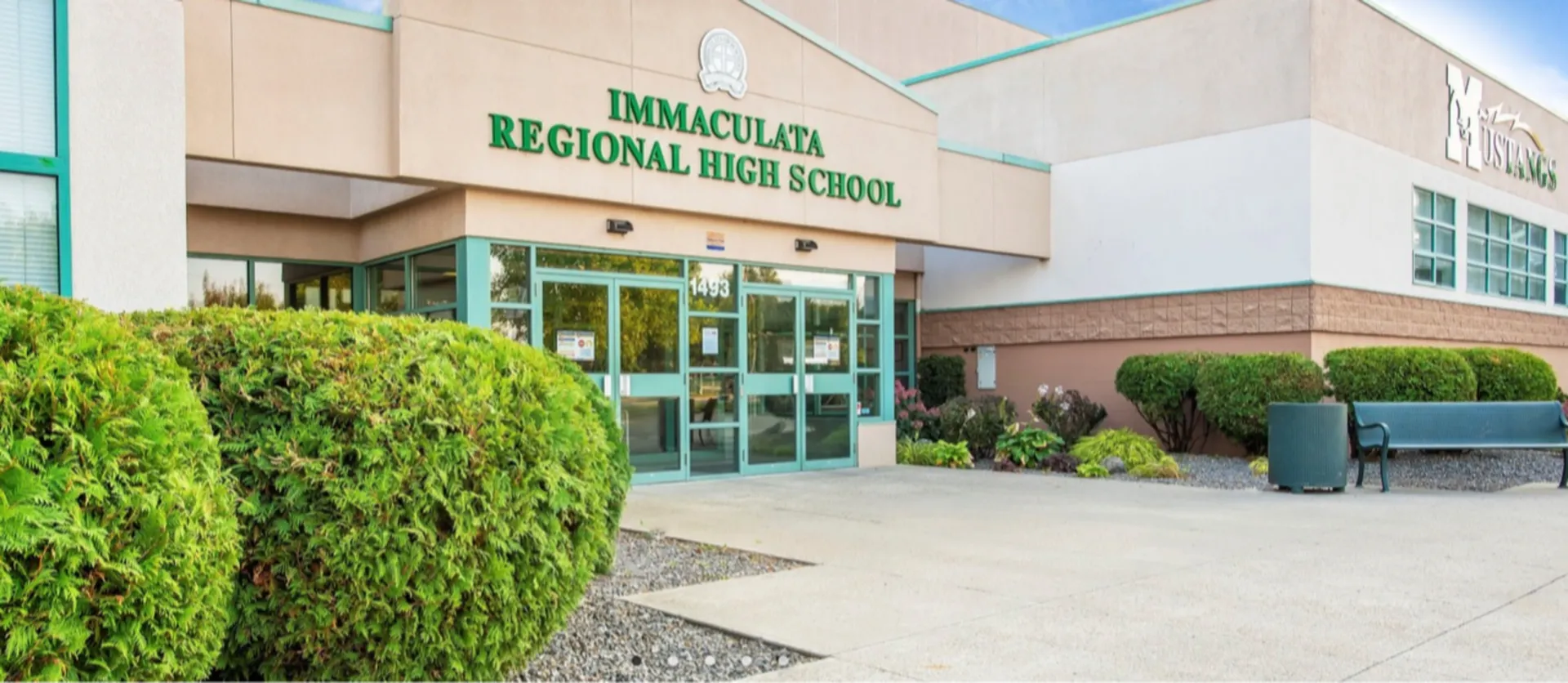 Se ve el moderno edificio de la Immaculata Regional School con una zona exterior cuidada y un entorno verde.