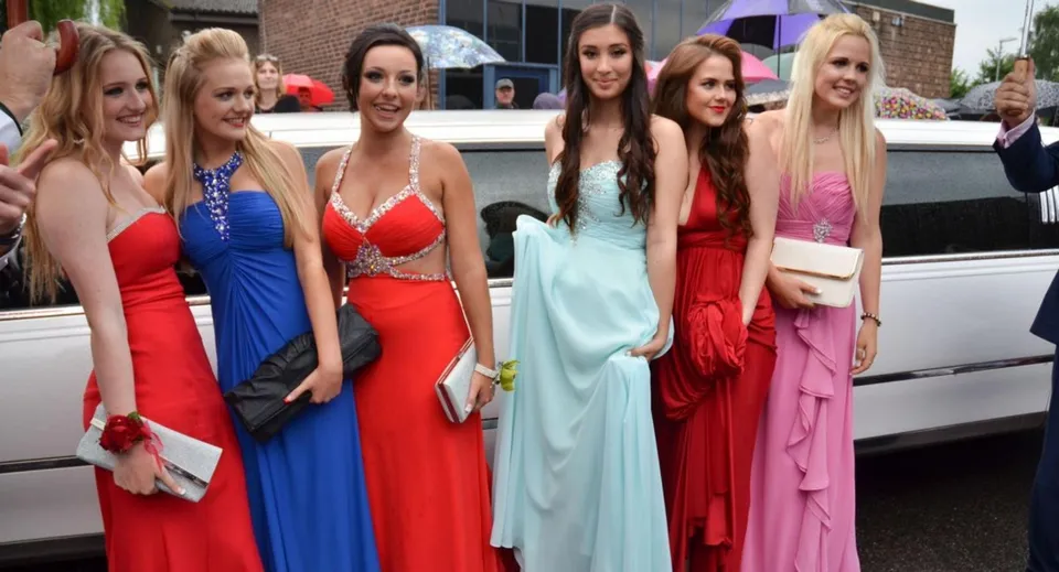 Sei studentesse della Grandview Heights Secondary School in abiti da sera posano davanti a una limousine bianca.