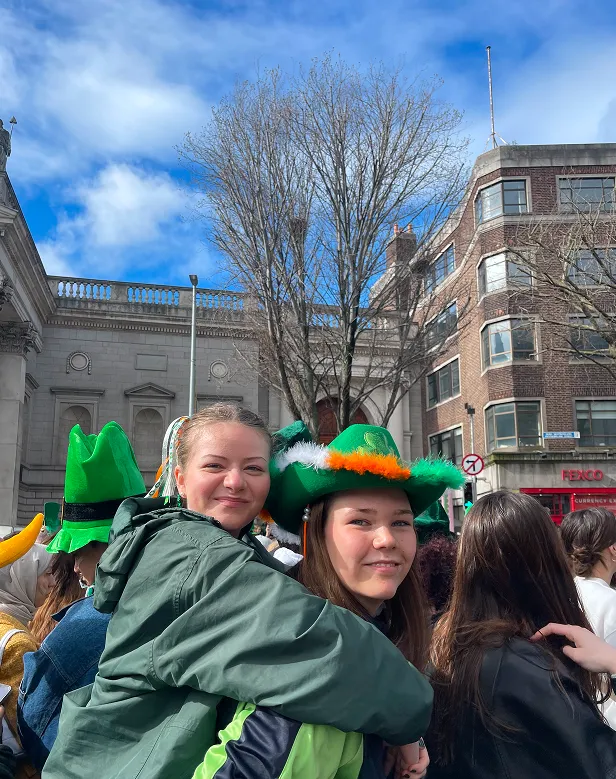 Dos chicas abrazadas con sombreros verdes en el desfile de San Patricio de Dublín