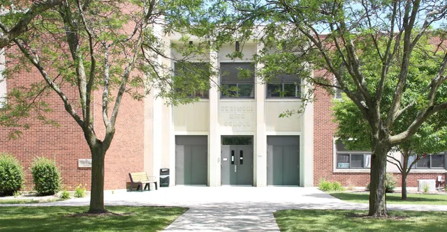 L'edificio moderno in mattoni con ampie finestre della St. Edmond Catholic School è circondato da una verde vegetazione e alberi.