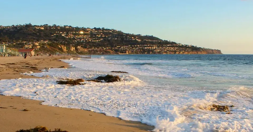 Un paesaggio costiero con una spiaggia sabbiosa ed edifici sulla collina vicino alla Torrance South High School.