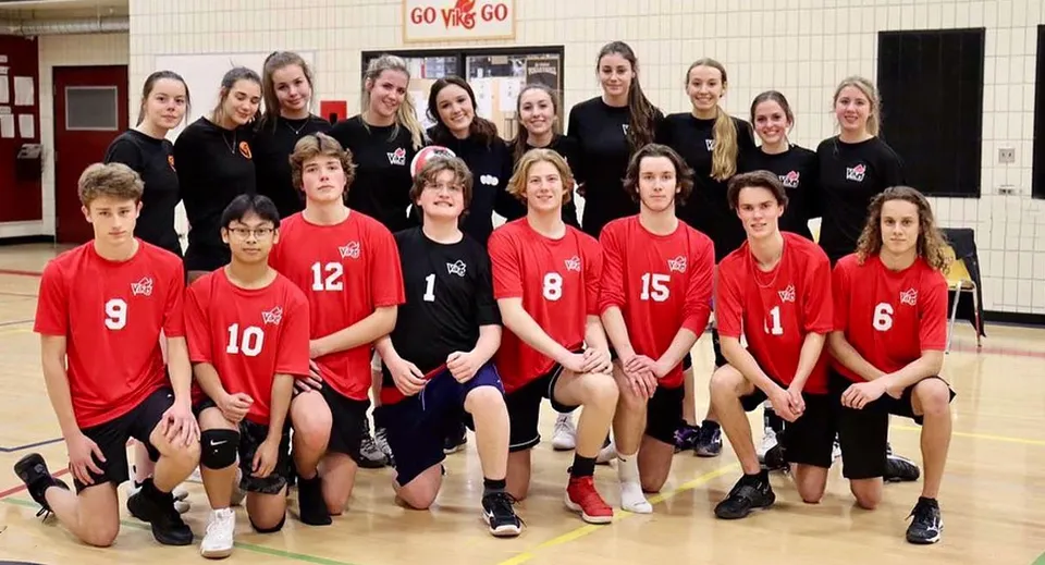 Un gruppo di studenti della Valleyview Secondary School in divisa rossa e nera posa in palestra davanti a un cartello Go Vikings.