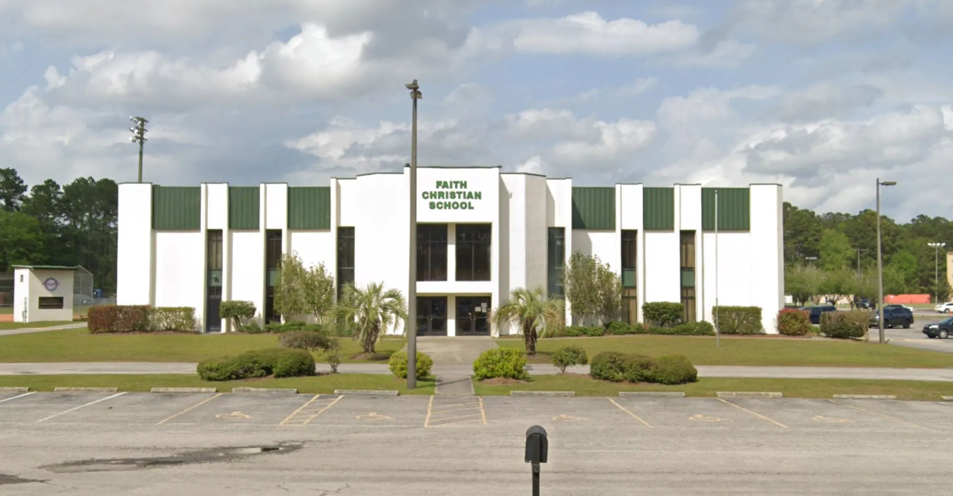 L'edificio moderno a più piani della Faith Christian School con un ambiente curato e un parcheggio in primo piano.