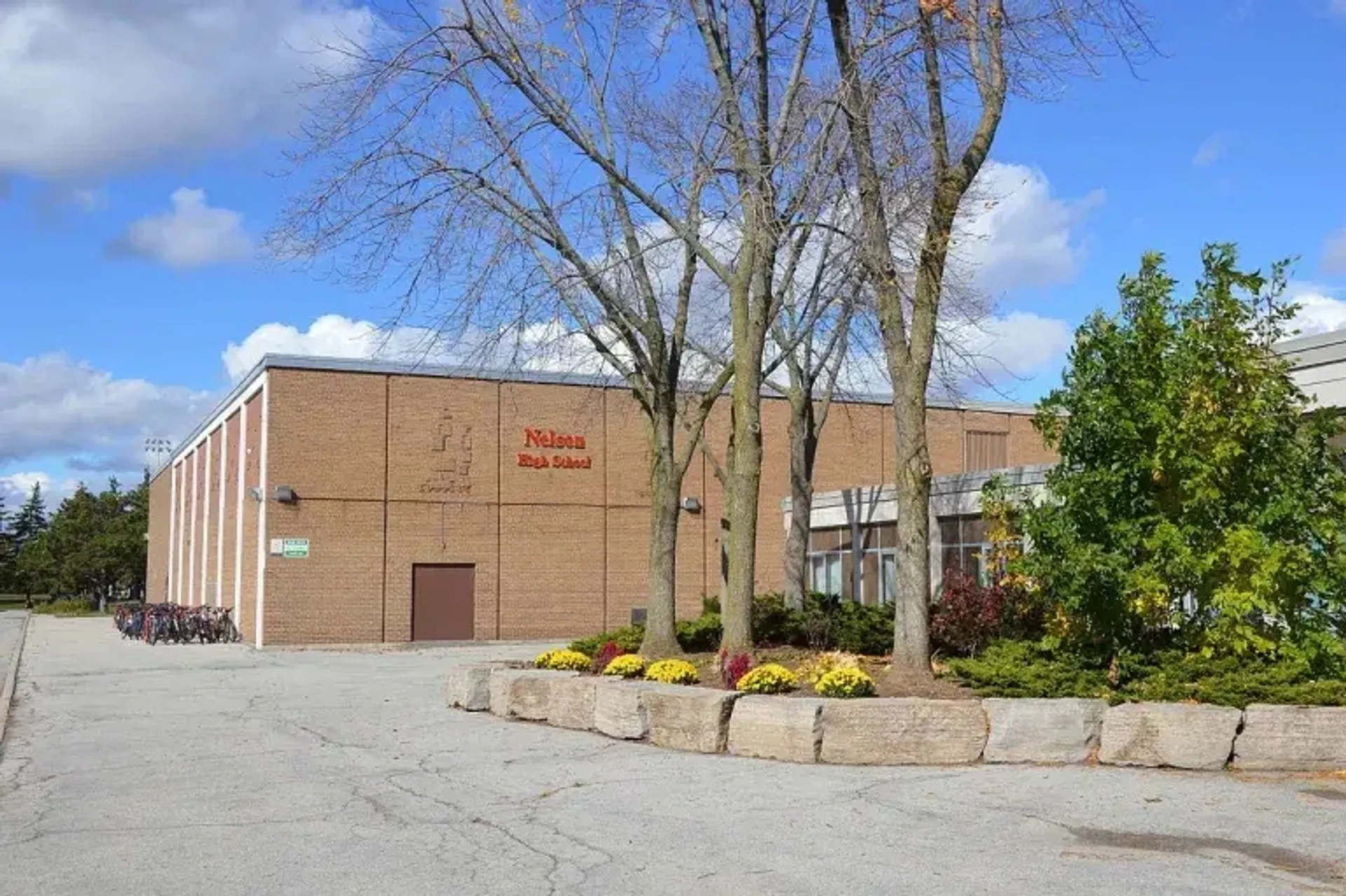 L'imponente edificio in mattoni della Nelson High School è circondato da alberi e aree verdi.