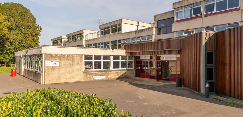 L'edificio a più piani della Somervale School con un'area d'ingresso pavimentata e verde circostante.
