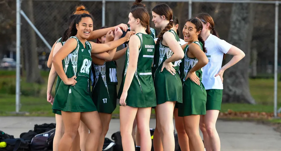 Studentesse della Burnside State High School festeggiano insieme sul campo sportivo.