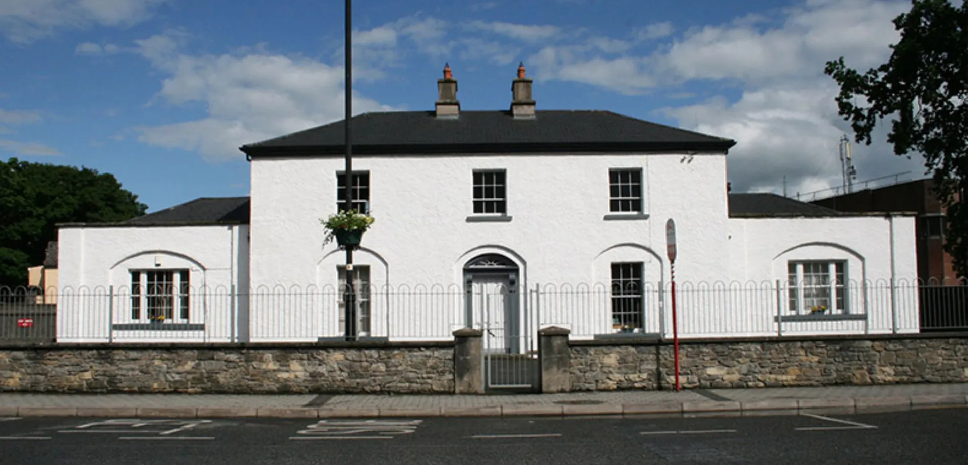 L'edificio bianco a due piani con archi e tetto nero nel campus della Royal School Cavan.
