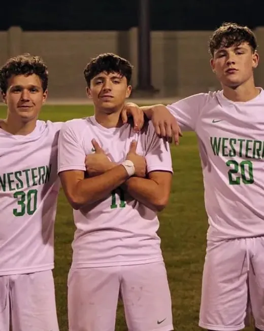 Tre studenti in maglia da calcio della squadra scolastica su un campo negli Stati Uniti