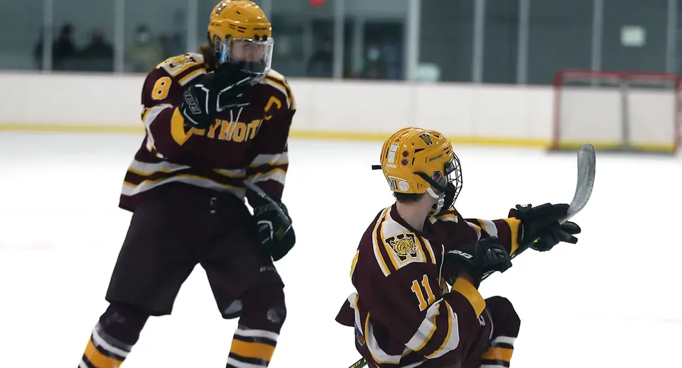 Due giocatori di hockey in tenuta da gioco completa si trovano sulla pista di ghiaccio della Erin District High School.