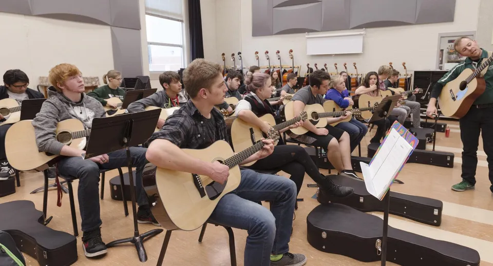 Studenti della North Peace Secondary School suonano diversi strumenti musicali in un'aula.