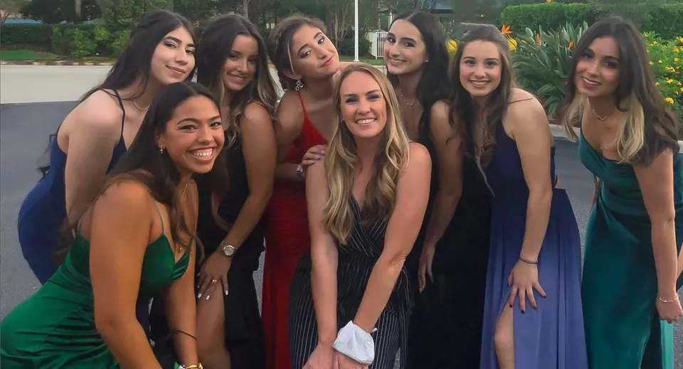Un gruppo di giovani donne in abiti colorati posa all'aperto nel campus della Sagemont School.