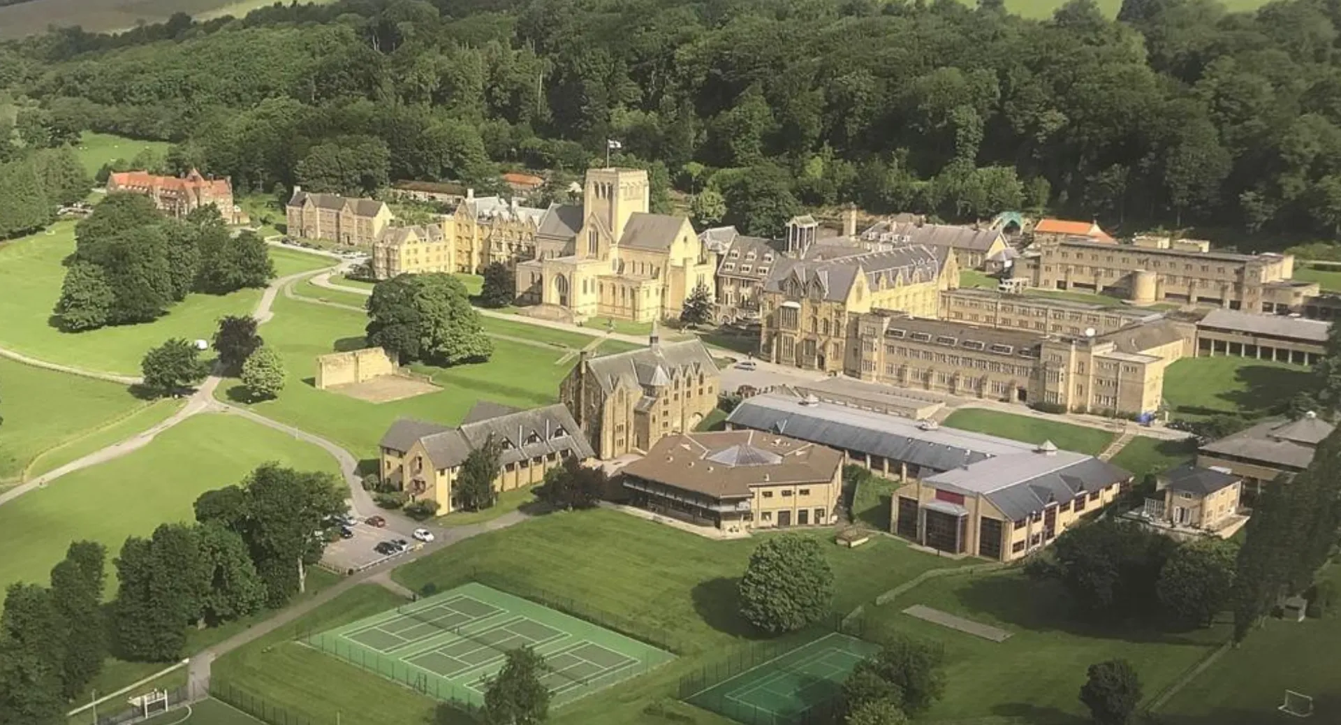 L'Ampleforth College mostra un castello medievale con prati ben curati e campi da tennis immersi in un paesaggio verde.