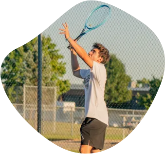 Austauschschüler beim Aufschlag auf dem Tennisplatz