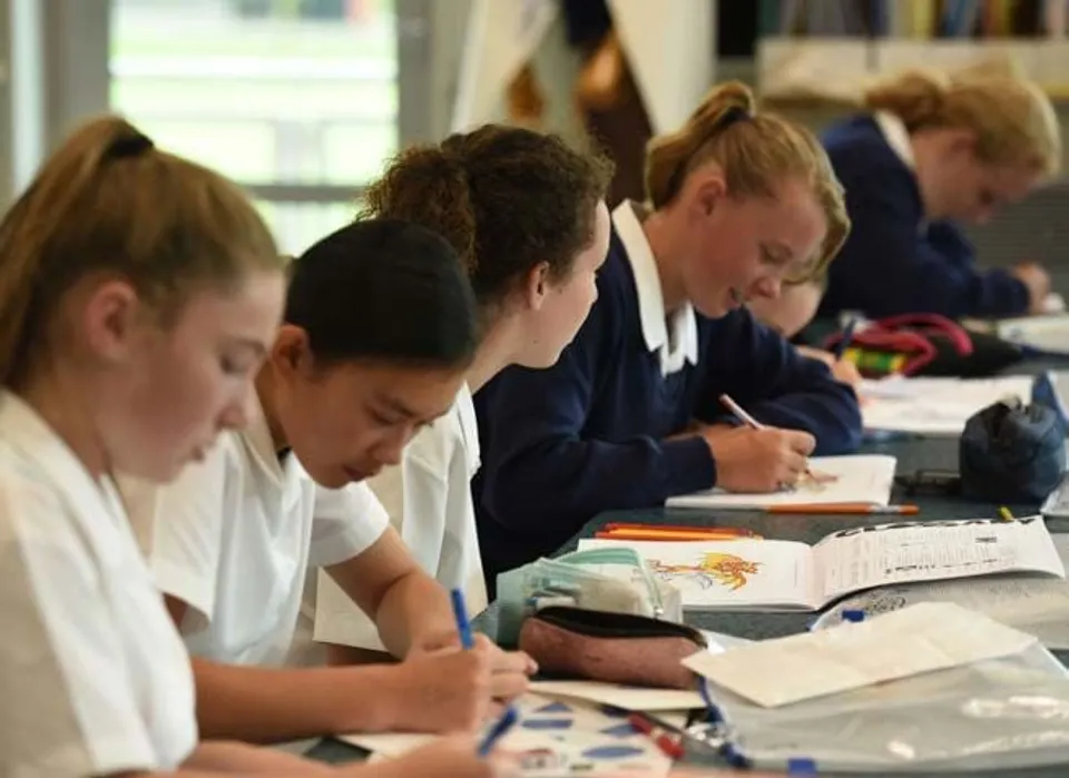 Studentesse della Timaru Girls School si concentrano sul loro lavoro con libri e fogli sui banchi.