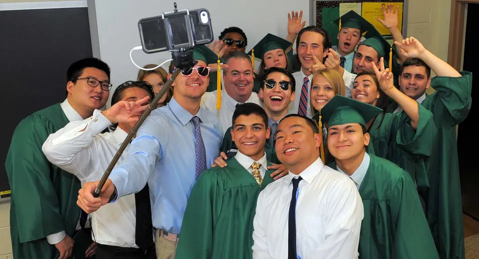Un gruppo di studenti della Burnside State High School festeggia insieme il diploma indossando la toga.