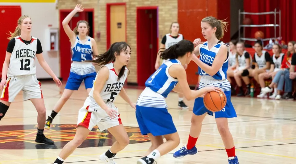 Un gruppo di giovani giocatrici di basket gioca una partita sul campo da basket della W.R Myers High School.